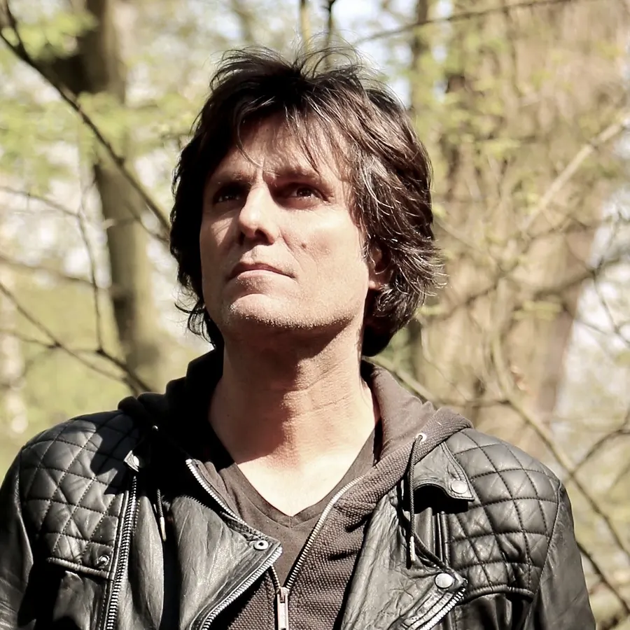 Close portrait of Lionel Fornetti in a leather jacket among trees