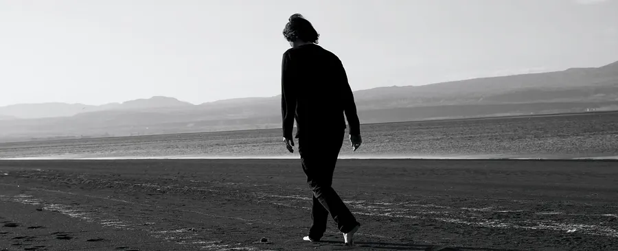 Lone silhouette walking on a beach, black and white
