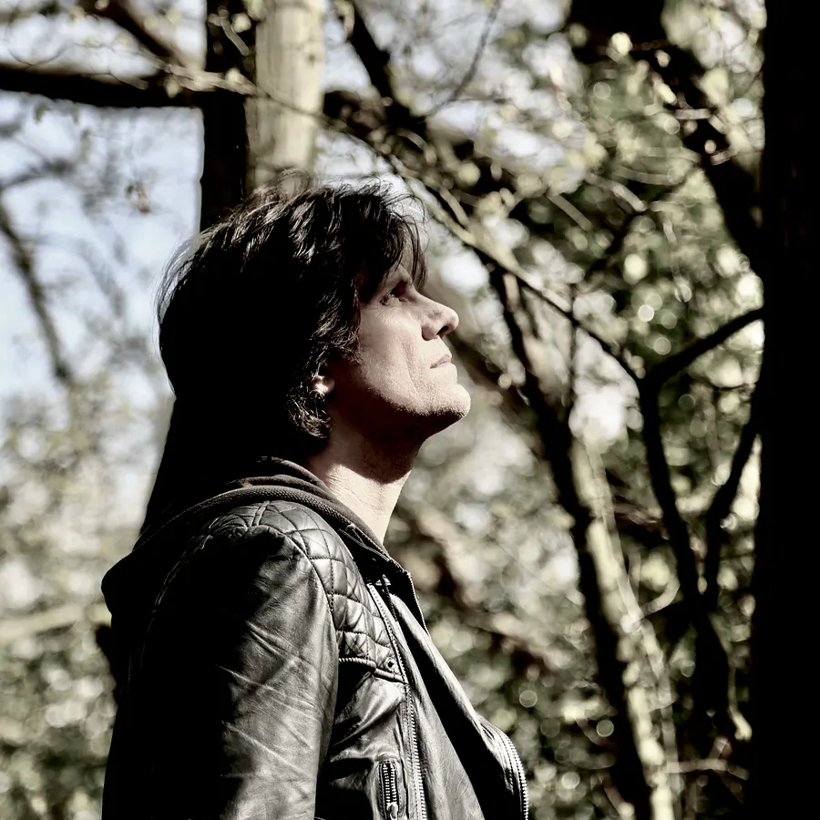 Lionel Fornetti in profile among trees, looking up