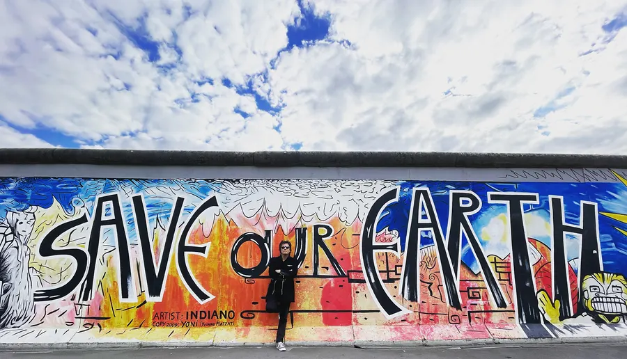 Lionel Fornetti in front of a “Save Our Earth” mural