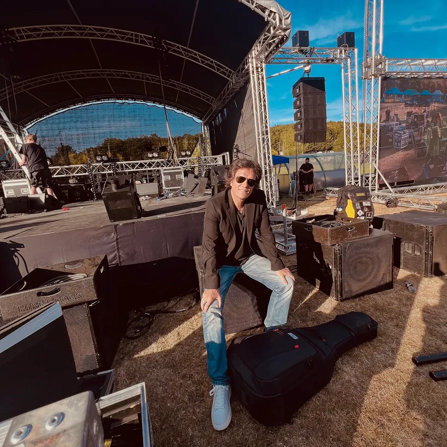Lionel Fornetti sitting on an open-air stage during set-up