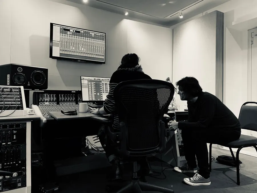 Two people in a studio control room, black and white