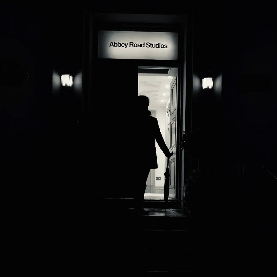 Dark doorway under an Abbey Road Studios sign, a silhouette inside