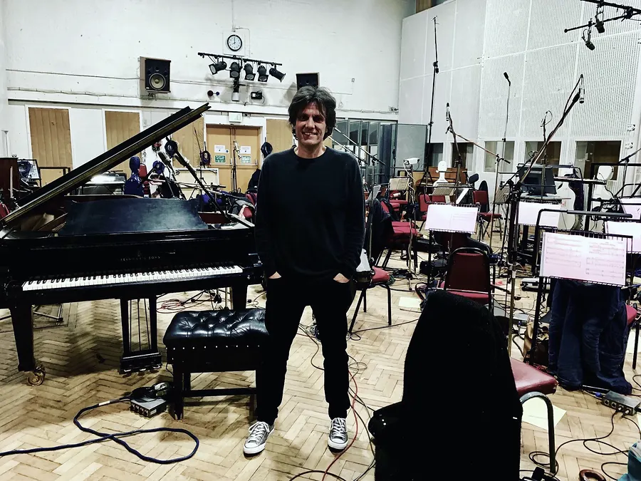 Lionel Fornetti standing in a large recording studio with a grand piano